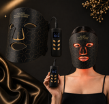 Black LED face mask with digital controller on a dark background